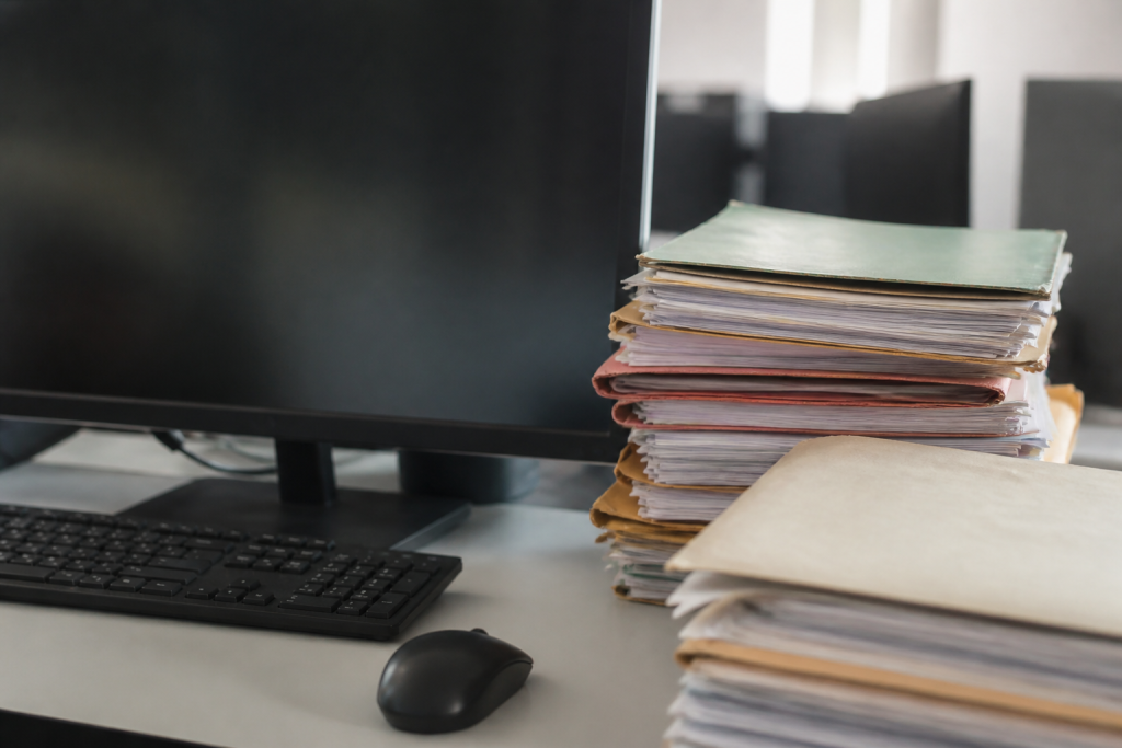 Ecran numerique avec dossiers comptables papier
