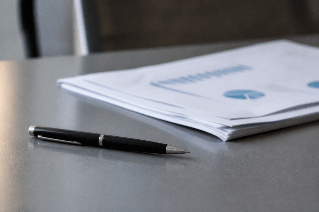Documents professionnels et stylo sur bureau gris
