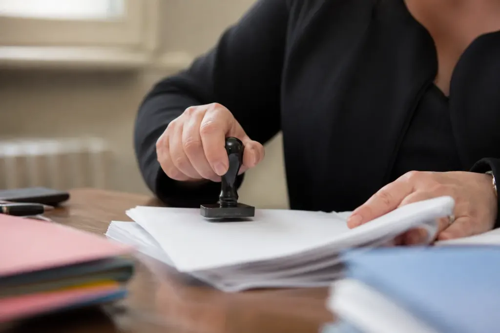 Main tenant un dossier papier avec tampon sur bureau