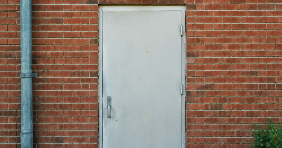 Numero blanc grave sur porte metal brique rouge