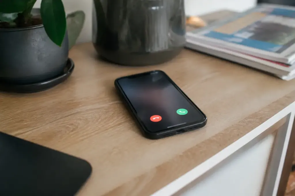 Smartphone posé sur bureau, écran affichant appel inconnu